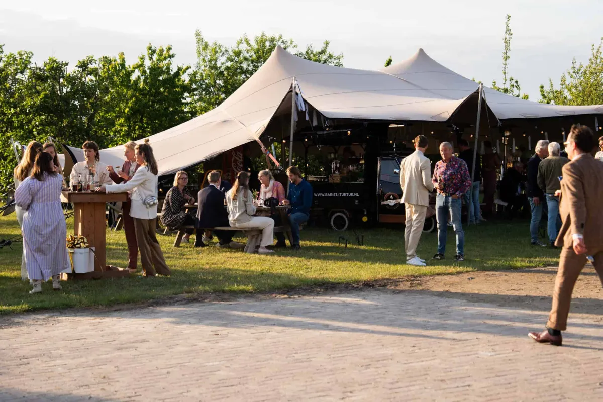 Party tent with guests at a summer event by BBakker Culinair