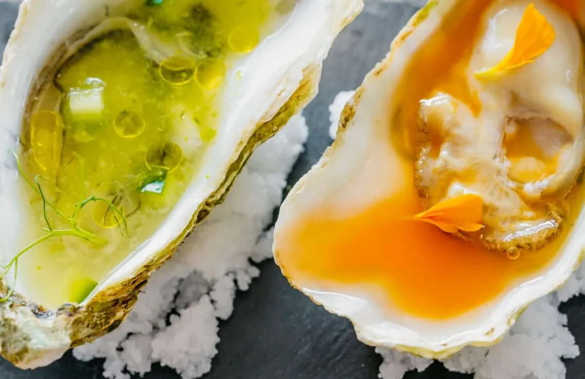 Twee oesters met verschillende smaken op zeezout