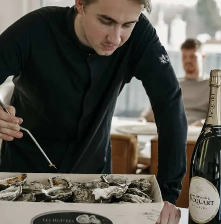 Booy Bakker opent oesters naast een fles champagne