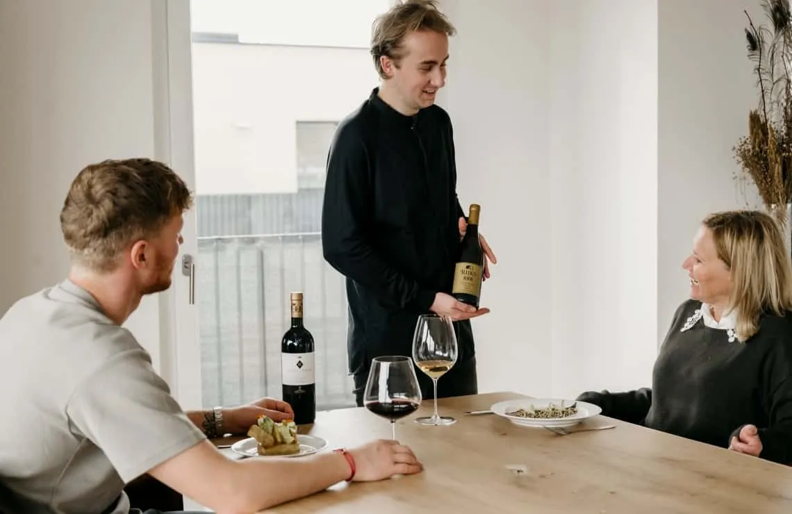 Booy Bakker schenkt wijn voor gasten aan tafel